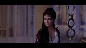 Movie still from “Cleopatra” (1963), directed by Rouben Mamoulian – A woman with long black hair wearing a white top; Medium shot, Over the shoulder angle