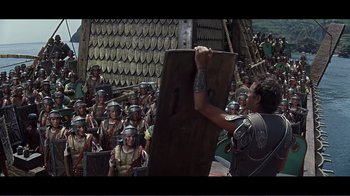 Movie still from “Cleopatra” (1963), directed by Rouben Mamoulian – A group of roman legionnaires are gathered in front of a crowd; Wide shot, High angle