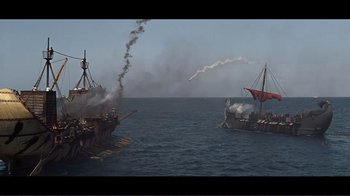 Movie still from “Cleopatra” (1963), directed by Rouben Mamoulian – Two ships in the water with smoke coming from them; Extreme Wide shot, High angle