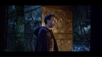 Movie still from “Cleopatra” (1963), directed by Rouben Mamoulian – A man wearing a hooded cloak standing in front of a wall; Medium shot, Low angle
