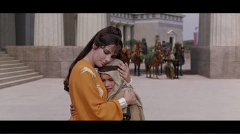 Movie still from “Cleopatra” (1963), directed by Rouben Mamoulian – A woman and a child are hugging in front of a crowd; Medium shot, High angle