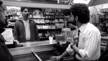 Movie still from “Clerks” (1994), directed by Kevin Smith – A man is talking to another man in a store; Medium shot, Over the shoulder angle