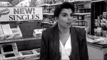 Movie still from “Clerks” (1994), directed by Kevin Smith – A black and white photo of a woman standing in a store; Medium shot, Low angle