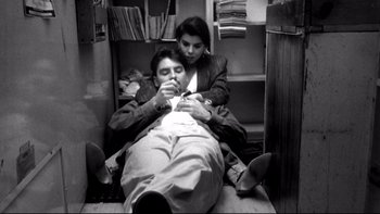 Movie still from “Clerks” (1994), directed by Kevin Smith – A man and a woman sitting on the floor; Medium shot, Overhead angle