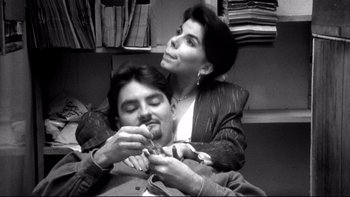 Movie still from “Clerks” (1994), directed by Kevin Smith – A man and a woman sitting in front of each other; Close Up shot, Overhead angle