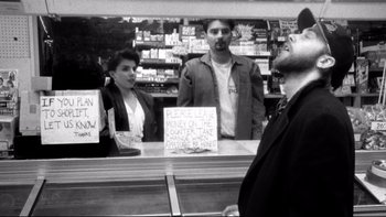 Movie still from “Clerks” (1994), directed by Kevin Smith – A man standing in front of two women in a store; Medium shot, Low angle