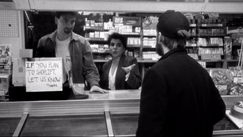 Movie still from “Clerks” (1994), directed by Kevin Smith – A man and a woman at a counter in a store; Medium shot, Over the shoulder angle