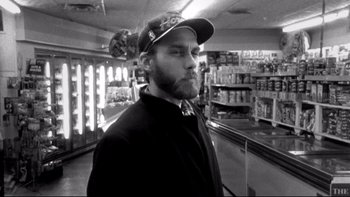 Movie still from “Clerks” (1994), directed by Kevin Smith – Black and white photograph of a bearded man in a store; Close Up shot, Over the shoulder angle