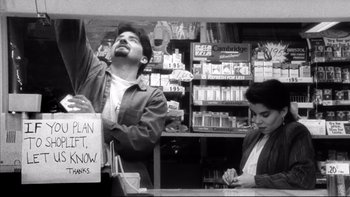 Movie still from “Clerks” (1994), directed by Kevin Smith – A man and a woman standing at a store counter; Medium shot, High angle