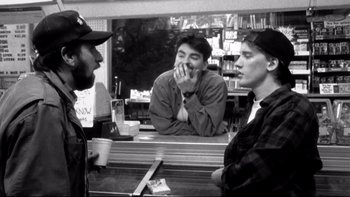 Movie still from “Clerks” (1994), directed by Kevin Smith – Three men are sitting at a counter in a restaurant; Medium shot, Over the shoulder angle