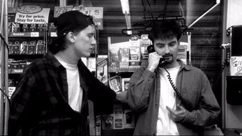 Movie still from “Clerks” (1994), directed by Kevin Smith – Two young men are talking on the phone; Medium shot, Low angle