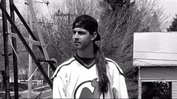 Movie still from “Clerks” (1994), directed by Kevin Smith – Black and white photograph of a man in a hockey uniform; Close Up shot, High angle
