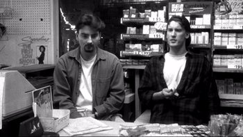 Movie still from “Clerks” (1994), directed by Kevin Smith – Two men sitting at a table in a store; Medium shot, Low angle