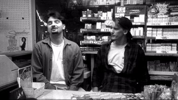 Movie still from “Clerks” (1994), directed by Kevin Smith – Two men sitting at a table in a store; Medium shot, Low angle