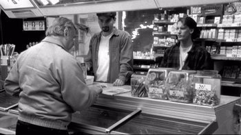 Movie still from “Clerks” (1994), directed by Kevin Smith – Three people are standing at a counter in a store; Medium shot, Over the shoulder angle