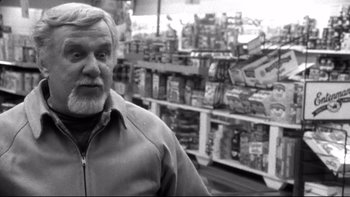 Movie still from “Clerks” (1994), directed by Kevin Smith – An older man standing in front of shelves of food; Close Up shot, Over the shoulder angle