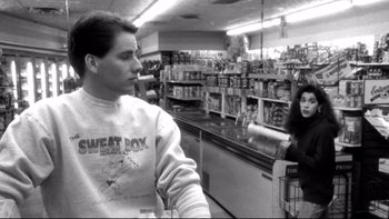 Movie still from “Clerks” (1994), directed by Kevin Smith – A man and a woman are standing in a grocery store; Medium shot, Low angle