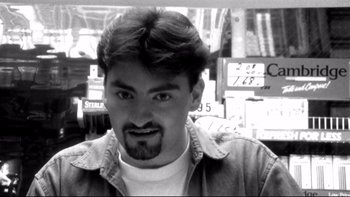 Movie still from “Clerks” (1994), directed by Kevin Smith – Black and white photograph of a man in a store; Close Up shot, Low angle