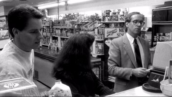 Movie still from “Clerks” (1994), directed by Kevin Smith – A man and a woman talking to a store clerk; Medium shot, Over the shoulder angle