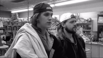 Movie still from “Clerks” (1994), directed by Kevin Smith – Two young men standing next to each other in a store; Close Up shot, Low angle