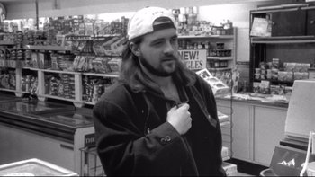 Movie still from “Clerks” (1994), directed by Kevin Smith – A black and white photo of a man in a store; Close Up shot, Low angle