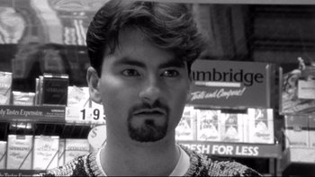 Movie still from “Clerks” (1994), directed by Kevin Smith – Black and white photograph of a man with a beard; Close Up shot, Low angle