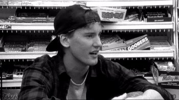 Movie still from “Clerks” (1994), directed by Kevin Smith – Black and white photograph of a young man in a store; Close Up shot, Low angle