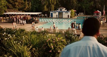 Movie still from “Click” (2006), directed by Frank Coraci – A group of people sitting around a swimming pool; Extreme Wide shot, Over the shoulder angle