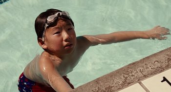Movie still from “Click” (2006), directed by Frank Coraci – A young boy in a swimming pool wearing goggles; Close Up shot, High angle