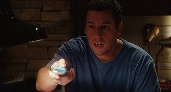 Movie still from “Click” (2006), directed by Frank Coraci – A man holding a remote control in his hand; Close Up shot, High angle