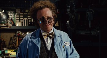 Movie still from “Click” (2006), directed by Frank Coraci – A man in a blue lab coat and a bow tie; Close Up shot, Over the shoulder angle