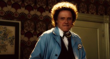 Movie still from “Click” (2006), directed by Frank Coraci – An older man in a blue jacket and a bow tie; Medium shot, Low angle