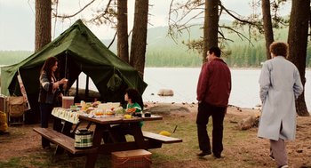 Movie still from “Click” (2006), directed by Frank Coraci – A man and a woman sitting at a picnic table near the water; Wide shot, Over the shoulder angle