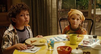 Movie still from “Click” (2006), directed by Frank Coraci – Two children sitting at a table with plates of food on it; Medium shot, Over the shoulder angle