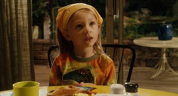 Movie still from “Click” (2006), directed by Frank Coraci – A little girl sitting at a table with a plate of food in front of her; Close Up shot, High angle