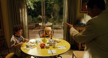 Movie still from “Click” (2006), directed by Frank Coraci – A child sitting at a yellow table in front of an adult; Medium shot, Over the shoulder angle