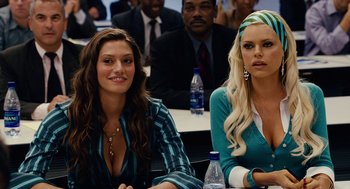Movie still from “Click” (2006), directed by Frank Coraci – Two women sitting in front of a group of people; Close Up shot, Over the shoulder angle