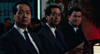Movie still from “Click” (2006), directed by Frank Coraci – A group of men in suits and ties sitting next to each other; Medium shot, Low angle