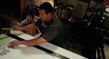 Movie still from “Click” (2006), directed by Frank Coraci – A man sitting at a table with a young boy; Medium shot, High angle