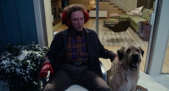 Movie still from “Click” (2006), directed by Frank Coraci – A man sitting in a chair with a dog; Medium shot, Over the shoulder angle