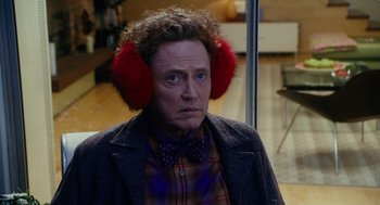 Movie still from “Click” (2006), directed by Frank Coraci – A man wearing ear muffs while wearing a bow tie; Close Up shot, Over the shoulder angle