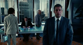 Movie still from “Click” (2006), directed by Frank Coraci – A man standing in front of two other men in a room; Medium shot, Over the shoulder angle