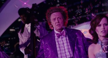 Movie still from “Click” (2006), directed by Frank Coraci – A man in a purple jacket and a bow tie; Medium shot, Over the shoulder angle
