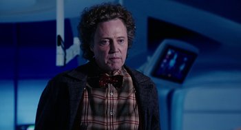 Movie still from “Click” (2006), directed by Frank Coraci – An older man wearing a plaid shirt and a bow tie; Close Up shot, Over the shoulder angle