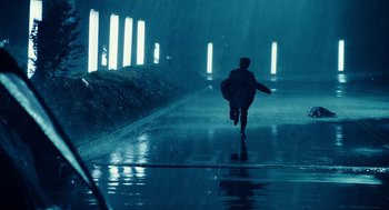 Movie still from “Click” (2006), directed by Frank Coraci – A person running in the rain on a rainy day; Extreme Wide shot, Low angle
