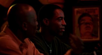 Movie still from “Clockers” (1995), directed by Spike Lee – A man sitting next to another man in a dark room; Close Up shot, Over the shoulder angle