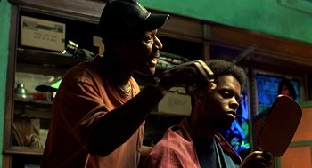 Movie still from “Clockers” (1995), directed by Spike Lee – A man is getting his hair cut by another man; Close Up shot, Low angle