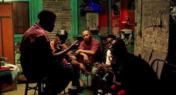 Movie still from “Clockers” (1995), directed by Spike Lee – A group of people sitting in a room together; Medium shot, High angle
