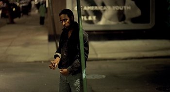 Movie still from “Clockers” (1995), directed by Spike Lee – A man standing next to a pole on the sidewalk; Medium shot, High angle