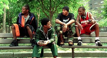 Movie still from “Clockers” (1995), directed by Spike Lee – A group of young men sitting on top of a wooden bench; Medium shot, Low angle